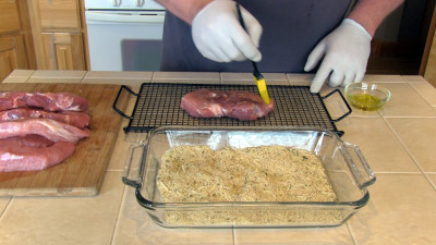 SmokingPit.com - Parmesan Encrusted Pork Loin Chops with fresh rosemary. Slow cooked on a Yoder YS640 Pellet cooker. Applying the olive oil.